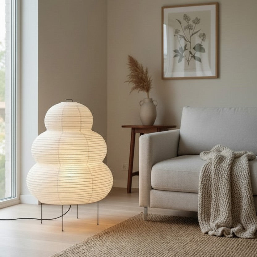 Modern living room Japandi Rice paper lamp with a textured floor lamp, armchair, and framed artwork.