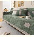 Green sofa with decorative cushions in a living room setting