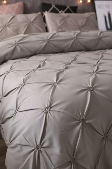 Gray textured luxepleat duvet cover by twinkle on a bed with pillows in a bedroom setting