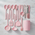 Pink kitchen utensil set on a marble surface