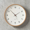 Tidings & Twinkle minimalist round wooden wall clock with white face and black numbers. Silent quartz movement.